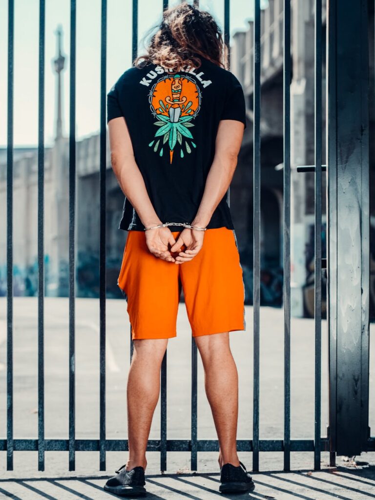 a man in handcuffs near a metal fence