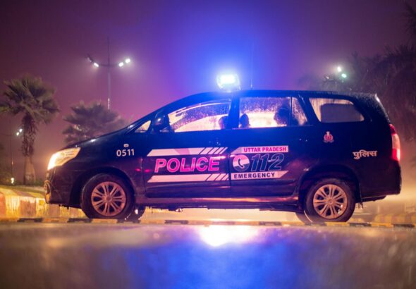side view of a police car parked by the roadside at night